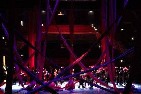 Flammend rote Stoffbahnen fallen aus dem Bühnenhimmel und werden auf bizarre Weise miteinander verknüpft. Eike Walkenhorst