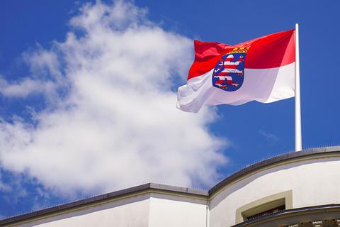 Die hessische Landesfahne weht auf dem Dach des hessischen Landtages vor dem Sommerhimmel.