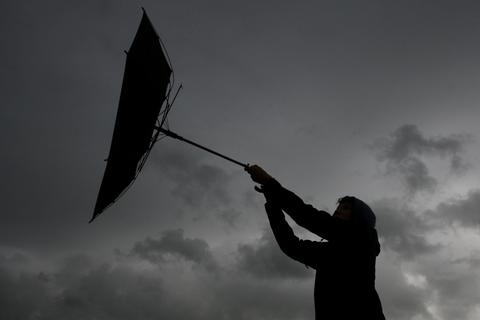 Eine Sturmböe entreißt einem Mann den Regenschirm. Archivfoto: dpa/Karl-Josef Hildenbrand