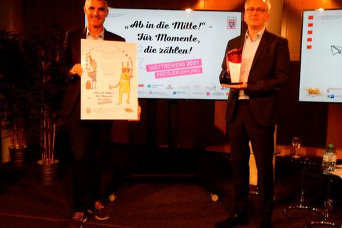 Moderator Tim Frühling und Minister Tarek Al-Wazir gratulieren der Strolchen-Stadt zum Gewinn. Foto: Stadtmarketing/Gußmann 