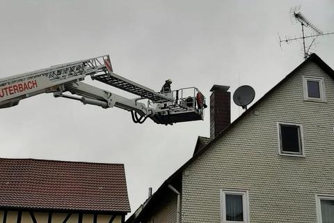 Der Schornsteinfeger über den Teleskopmast der Feuerwehr Lauterbach auf das Dach gebracht, damit er den Kamin wieder freibekommen konnte. © Fuldamedia