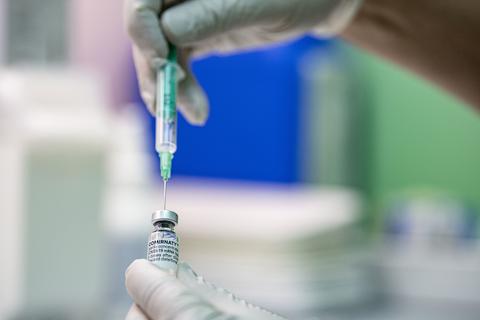 Ein Arzt zieht den Corona-Impfstoff Comirnaty von Biontech/Pfizer in eine Spritze. Foto: dpa