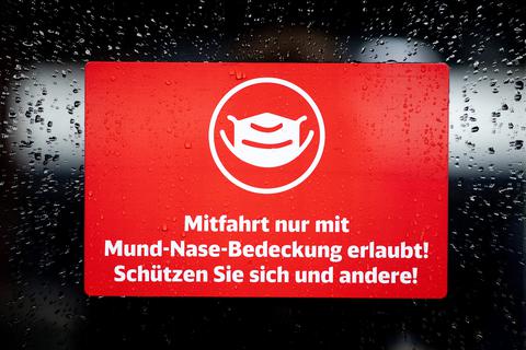 Ein Schild mit der Aufschrift "Mitfahrt nur mit Mund-Nase-Bedeckung erlaubt! Schützen Sie sich und andere!" klebt an der Zugtür eines ICE der Deutschen Bahn. Foto: dpa