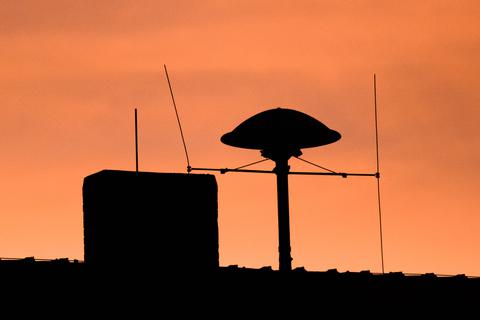 Die Konturen einer Sirene zeichnen sich auf dem Dach einer Grundschule vor dem Morgenhimmel ab. Archivfoto: dpa