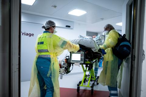 Die Besatzung eines niederländischen Krankenwagens schiebt einen Covid-19-Patienten aus den Niederlanden im St. Elisabeth Hospital an einem Raum mit der Aufschrift "Triage" vorbei. Foto: dpa