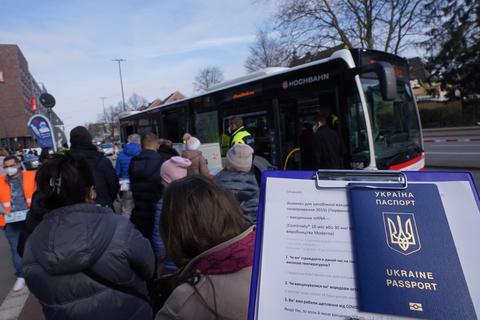 Ukrainische Flüchtlinge in Hamburg vor einem Bus. Dort bietet ein mobiles Impfteam Corona-Schutzimpfungen an.  Foto: dpa