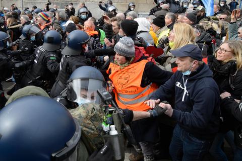 Dicht an dicht in der Kasseler Innenstadt: Polizisten mit Helm, Demonstranten ohne Masken. Foto: dpa
