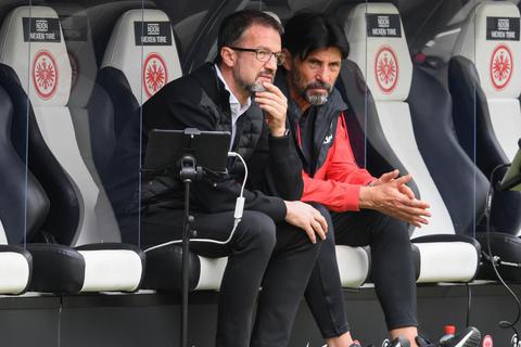 Fredi Bobic (l), scheidender Sportvorstand von Eintracht Frankfurt, und der ebenfalls Abschied nehmende Sportdirektor Bruno Hübner verfolgen das Spiel gegen Freiburg. Foto: dpa