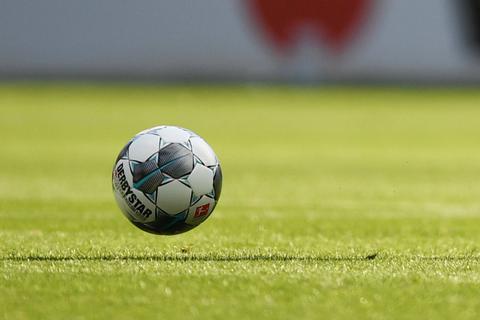 Ein Fußball wird über den Rasen gekickt.  Symbolfoto: dpa