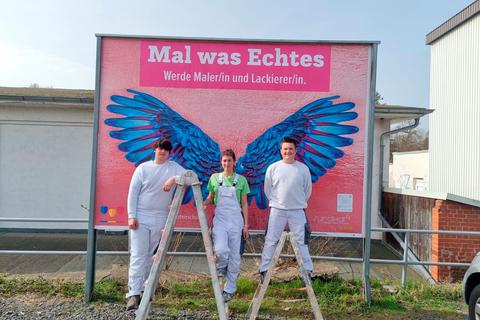 Max Meister, Maja Meister und Lucas Mattern (von links) gestalteten die Plakatwand, die am Bahnhof in Lauterbach zu sehen ist. Foto: Kreishandwerkerschaft 